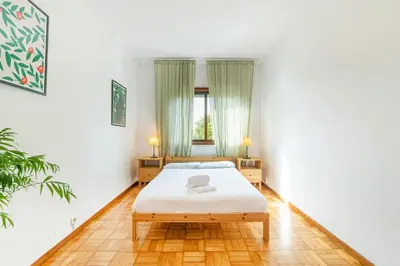 a white bedroom with a bed and a window at Bonfim Sunny Vintage apartment in Porto