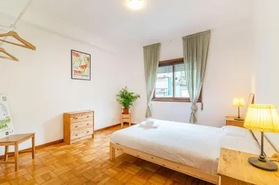 a bedroom with a bed and a desk and a window at Bonfim Sunny Vintage apartment in Porto