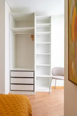 a bedroom with a closet with a bed and a chair at Host Wise - Bright and Cozy House with Dom Luís Bridge View in Porto