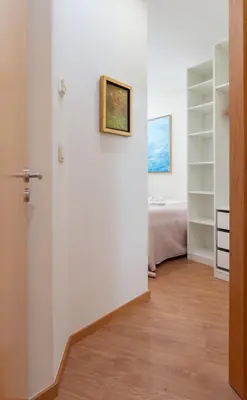 a hallway with white walls and a bed in a room at Host Wise - Bright and Cozy House with Dom Luís Bridge View in Porto