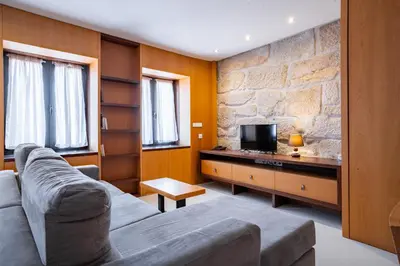 a living room with a couch and a tv at Smartr Porto Reis de Gaia & Spa in Vila Nova de Gaia