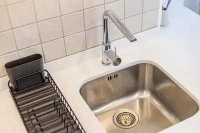 a kitchen sink with a dish drying rack next to it at Porto Cozy and Design Apartment in Porto Center in Porto