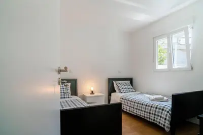 a bedroom with two beds and a window at Casa da fonte in Vila Nova de Gaia