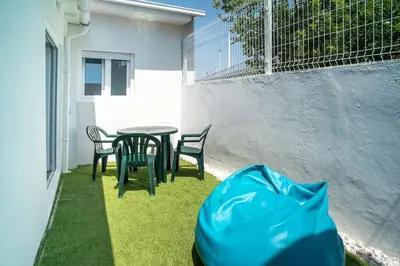 a patio with a table and chairs on the grass at Casa da fonte in Vila Nova de Gaia