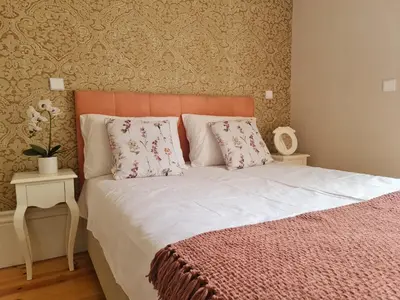 a bed with an orange headboard and two pillows at Tomás Stay City Center Porto in Porto