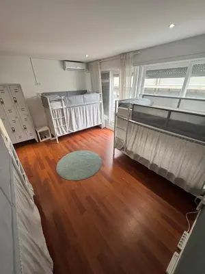 a bedroom with two beds and a wooden floor at Dormitório Aliados in Porto