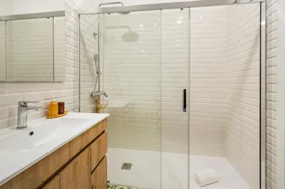 a bathroom with a sink and a glass shower at GuestReady - Alegria Guesthouse in Porto