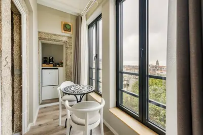 a room with a table and chairs and large windows at GuestReady - Alegria Guesthouse in Porto