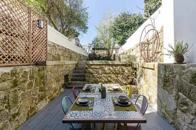 a table and chairs on a patio with stairs at GuestReady - Alegria Guesthouse in Porto