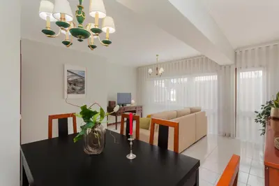 a dining room and living room with a black table and chairs at Guilhermina's Place in Vila Nova de Gaia