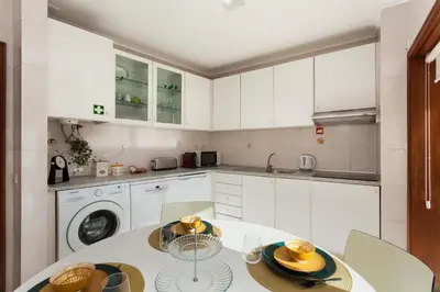 a kitchen with a table and a washing machine at Guilhermina's Place in Vila Nova de Gaia