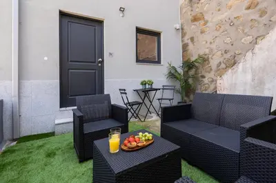 a patio with two chairs and a table with a bowl of fruit at Host Wise - Stylish Duplex House - Terrace & River View in Vila Nova de Gaia