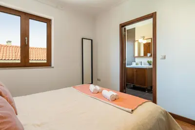 a bedroom with a bed with a mirror and a sink at Host Wise - Spacious Duplex House - Jacuzzi & Terrace in Porto