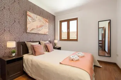 a bedroom with a bed with two towels on it at Host Wise - Spacious Duplex House - Jacuzzi & Terrace in Porto