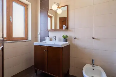 a bathroom with a sink and a mirror and a toilet at Host Wise - Spacious Duplex House - Jacuzzi & Terrace in Porto