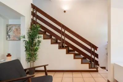a staircase in a living room with a chair at Host Wise - Spacious Duplex House - Jacuzzi & Terrace in Porto