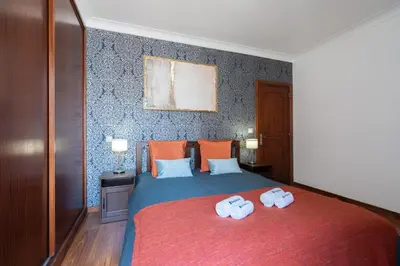 a bedroom with a bed with two towels on it at Host Wise - Spacious Duplex House - Jacuzzi & Terrace in Porto