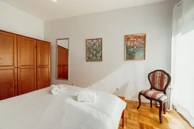 a bedroom with a white bed and a chair at Downtown Aquarelle by Vacationy in Porto