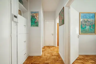 a hallway with white walls and wooden floors and paintings at Downtown Aquarelle by Vacationy in Porto