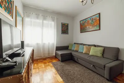 a living room with a couch and a television at Downtown Aquarelle by Vacationy in Porto