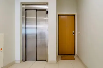 a hallway with two elevators and a brown door at Sunny Priorado Vintage studio with balcony in Porto