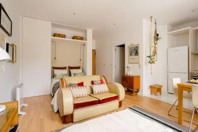 a bedroom with a bed and a couch and a table at Sunny Priorado Vintage studio with balcony in Porto