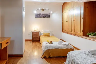 a small bedroom with two beds and a cabinet at Host Wise - Rustic Bright Flat - City Centre in Porto