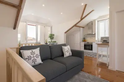 a living room with a couch and a kitchen at Host Wise - Modern Comfy Flat in Porto