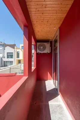 an empty hallway of a red building with a window at Host Wise - Modern Comfy Flat in Porto