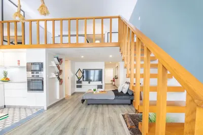 a living room with a bed and a staircase at Host Wise - Deluxe Spacious Flats w Mezzanine in Porto