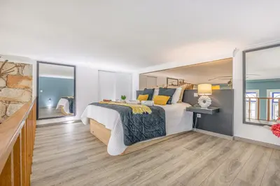 a white bedroom with a large bed and windows at Host Wise - Deluxe Spacious Flats w Mezzanine in Porto