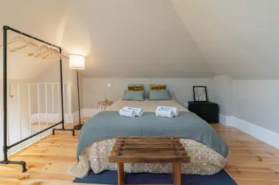 a bedroom with a large bed with a wooden floor at Host Wise - Modern Design Duplex w Balcony in Porto