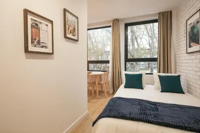 a bedroom with a bed and a window and a table at Marquês Oporto Apartment in Porto