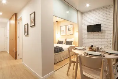 a room with a bed and a table with chairs at Marquês Oporto Apartment in Porto