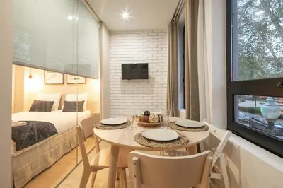 a room with a table and chairs and a bedroom at Marquês Oporto Apartment in Porto