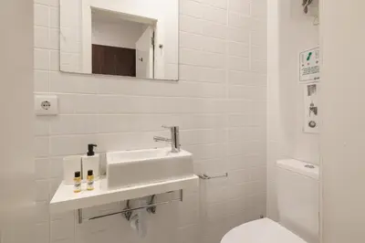 a white bathroom with a sink and a toilet at Marquês Oporto Apartment in Porto