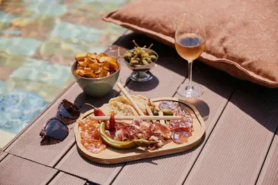 a table with a plate of food and a glass of wine at The Social Hub Porto in Porto