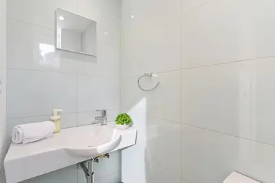a white bathroom with a sink and a shower at Coliseu Oporto Center in Porto