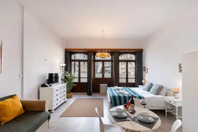 a living room with a couch and a table at Poveiros Studio OPorto City Center in Porto