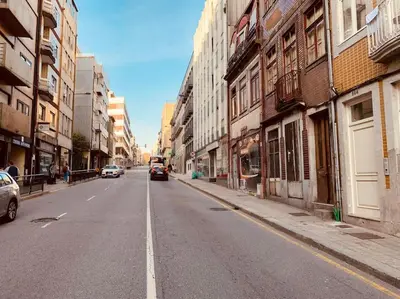an empty city street with cars driving down the street at Santa Catarina Oporto City Center in Porto