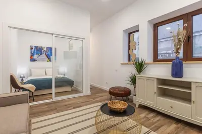 a living room with a bed and a couch and a table at Bright apartment with garden in Porto