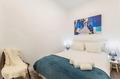 a bedroom with a bed and a painting on the wall at Bright apartment with garden in Porto