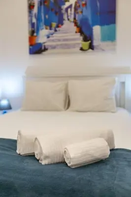 two white towels sitting on top of a bed at Bright apartment with garden in Porto