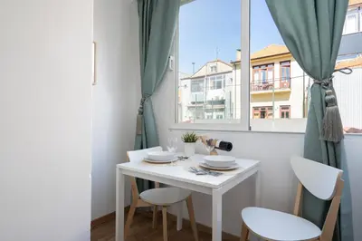 a small white table with two chairs and a window at Host Wise - Enchanting Unique Flat - Ace Location in Porto