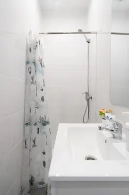 a white bathroom with a sink and a shower curtain at Host Wise - Enchanting Unique Flat - Ace Location in Porto