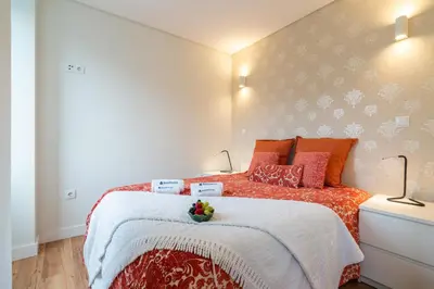 a bedroom with a large bed with orange pillows at Host Wise - Large Colourful Flats - Ace Location in Vila Nova de Gaia