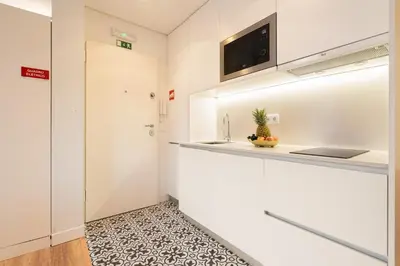 a kitchen with white walls and a counter with a sink at Host Wise - Large Colourful Flats - Ace Location in Vila Nova de Gaia