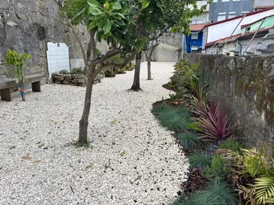 a gravel pathway with trees and a stone wall at Charming 2BR w Terrace & Garden in Porto