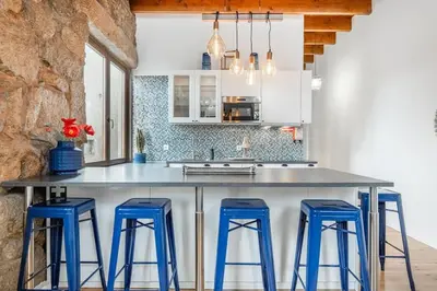 a kitchen with a large island with blue bar stools at Charming 2BR w Terrace & Garden in Porto