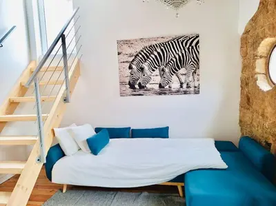 a room with a blue couch and a painting of zebras at Charming 2BR w Terrace & Garden in Porto